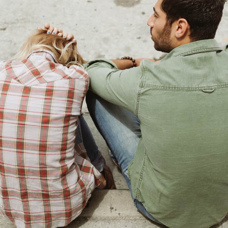 A person in BPD relationship with their head in their hands, indicating distress and feeling overwhelmed.