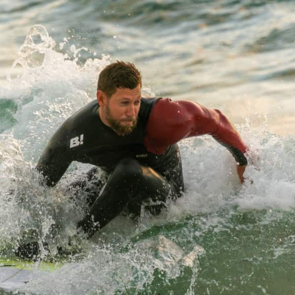 A man skillfully surfing a wave, symbolizing mastery over emotional regulation and maintaining balance amidst life's challenges.