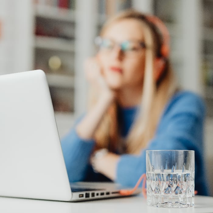 Blurred woman focused on a computer screen, showcasing the impact of prolonged digital engagement on mental health and social media and depression