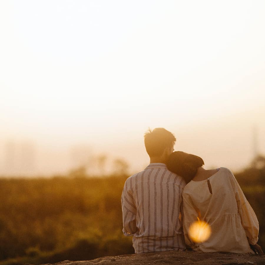 A man and woman standing together at sunset, symbolizing the complex dynamics of relationships affected by Anxious Preoccupied Attachment style.