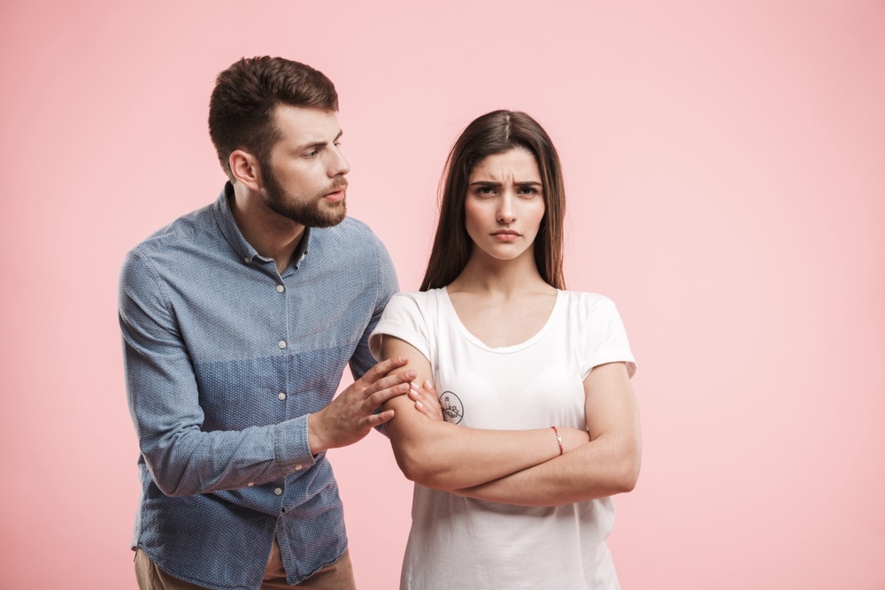 Husband convincing his wife who refuse to get mental help for depression, pink background