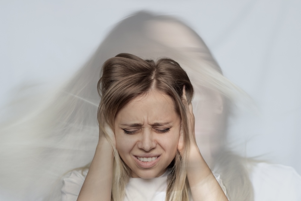 Adult female struggling with schizophrenia clutching her head