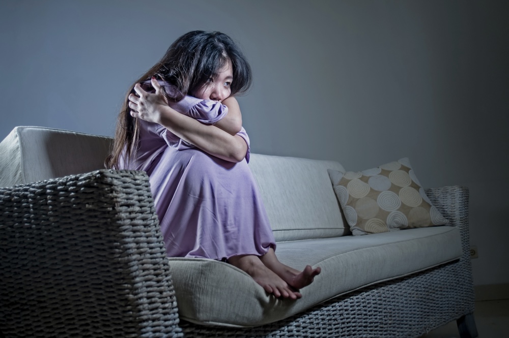 Woman on the couch in her pajamas struggling with anxiety symptoms