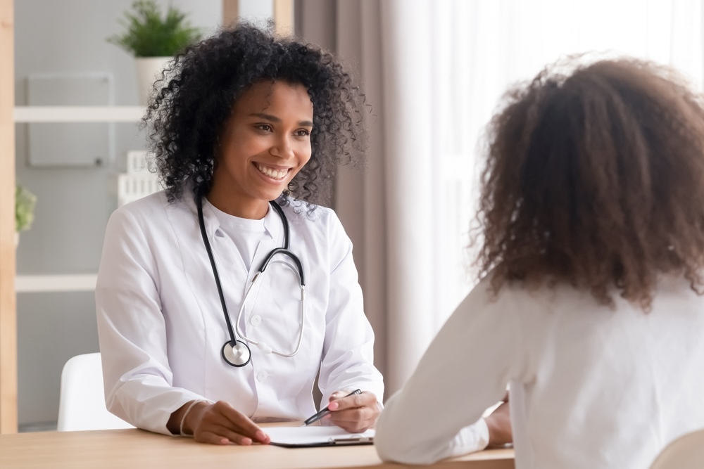 Female psychiatrist smiling while speaking to a mental health patients about prescription medications 