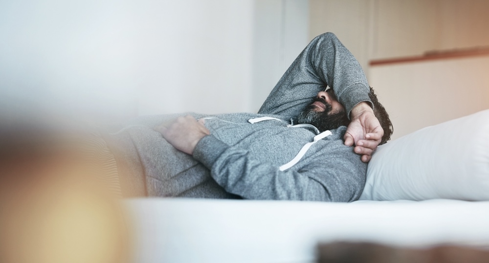 Man feeling depressed isolating himself inside the bedroom