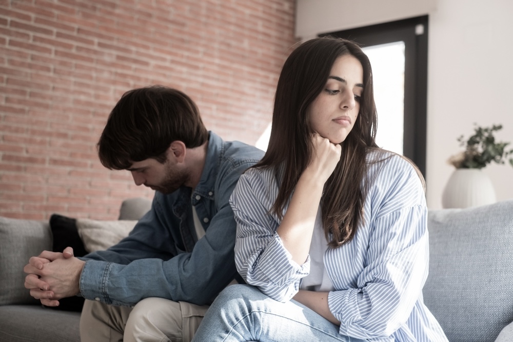 Sad man and woman breaking up, with one of them depressed