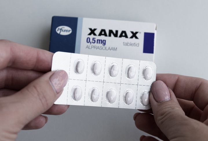 Man holding Xanax pills with box on the background